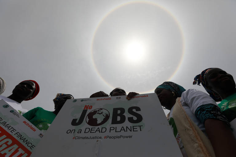 Uma halo solar se forma enquanto manifestantes se reúnem durante protesto em Abuja, na Nigéria