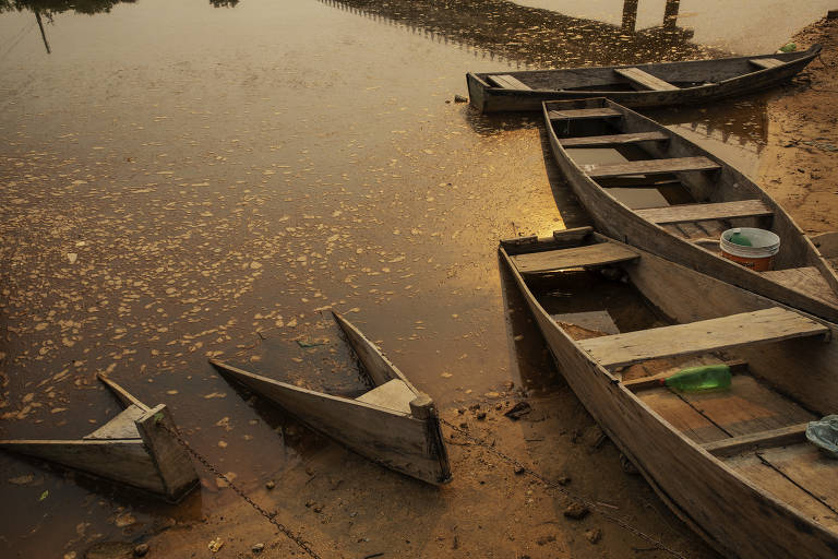 Canoas usadas por pescadores ficam presas no barro, no rio Peixoto de Azevedo, no norte do Mato Grosso