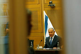 Israeli Prime Minister Benjamin Netanyahu looks on as he delivers a statement to the media at the start of his Likud party faction meeting at the Knesset, Israel's parliament, in Jerusalem