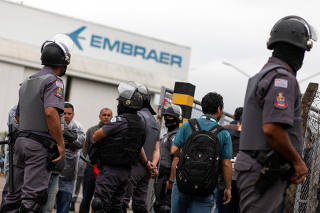 Police officers take position in front of the Embraer's plant in Sao Jose dos Campos