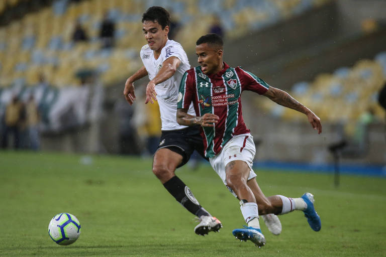 O santista Aguilar tenta tomar a bola de Allan, do Fluminense, no duelo desta quinta-feira no Maracanã