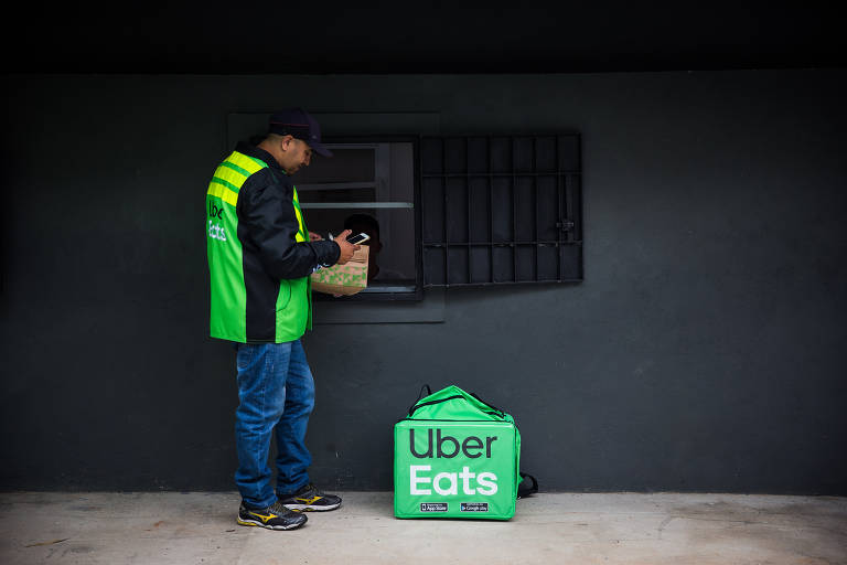 Entregador busca o pedido em janela no HUB CK, que funciona como coworking de cozinhas só para delivery da Uber Eats