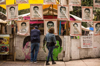 Photographs of the 43 students abducted in Iguala five years ago line a makeshift camp in downtown Mexico City, Sept. 19, 2019. (Celia Talbot Tobin/The New York Times)