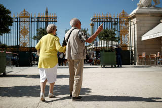 A couple of elderly people arrives at the Tuileries Garden in Paris