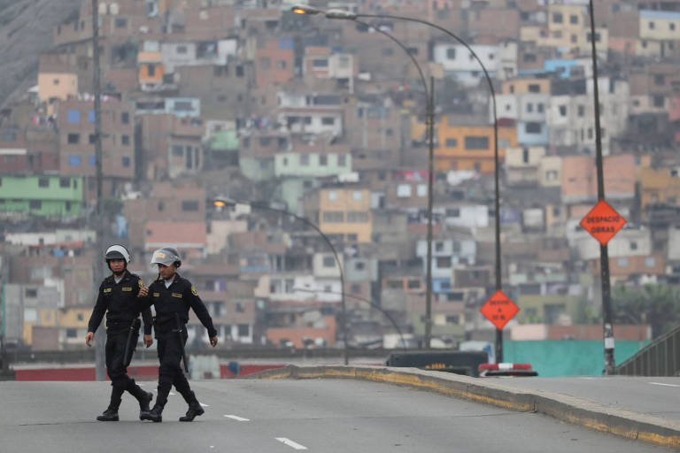 Policiais caminham em rua fechada ao tráfego próximo ao prédio do Congresso peruano, em Lima
