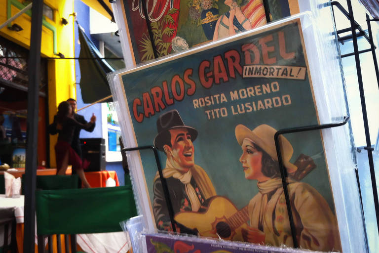 Cartão postal com imagem de Carlos Gardel, cantor de tango argentino, segurando um violão e cantando para uma mulher