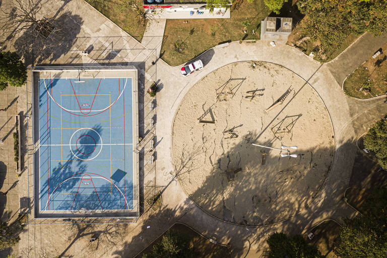 Vista aérea da quadra poliesportiva e do parquinho da praça. Em frente a uma base da Polícia Militar, são áreas que ainda estão bem conservadas