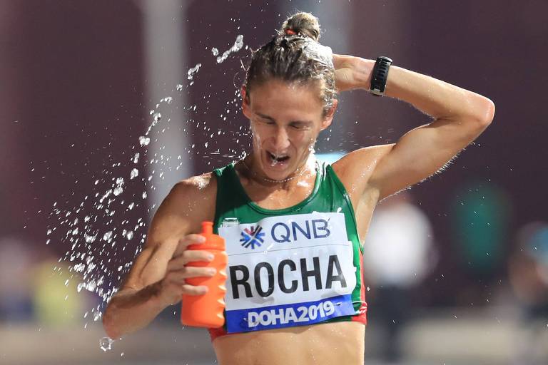 A portuguesa Carla Salomé Rocha se refresca durante a maratona do Mundial de Doha; ela foi uma das 40 competidoras que conseguiu cruzar a linha de chegada