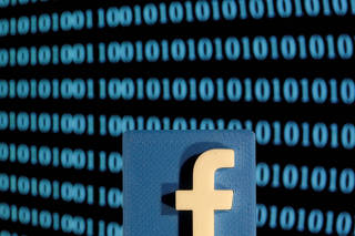 FILE PHOTO: A 3-D printed Facebook logo is seen in front of displayed binary code in this illustration picture