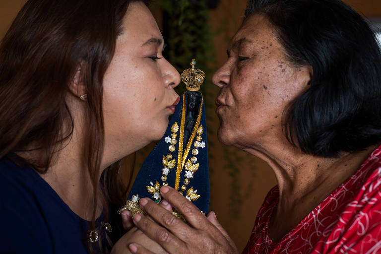 A advogada Elaine Aparecida da Silva, 42 anos, com a mãe, a dona de casa Glória Maria Balbino da Silva, 70, beijam a imagem de Nossa Senhora Aparecida; as duas são devotas 