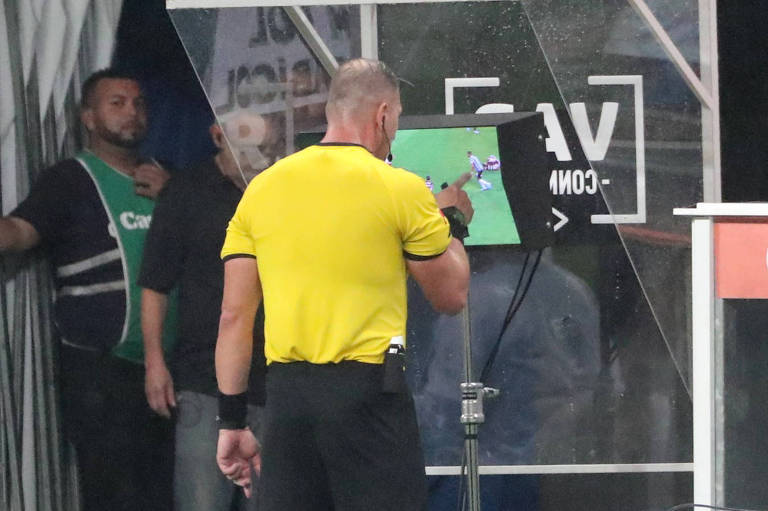 O árbitro argentino Nestor Pitana consulta o VAR durante Grêmio x Flamengo; equipe carioca teve três gols anulados na partida
