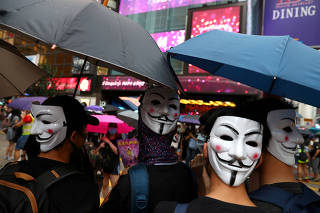 Anti-government protesters wear masks during a demonstration at Causeway Bay district, in Hong Kong
