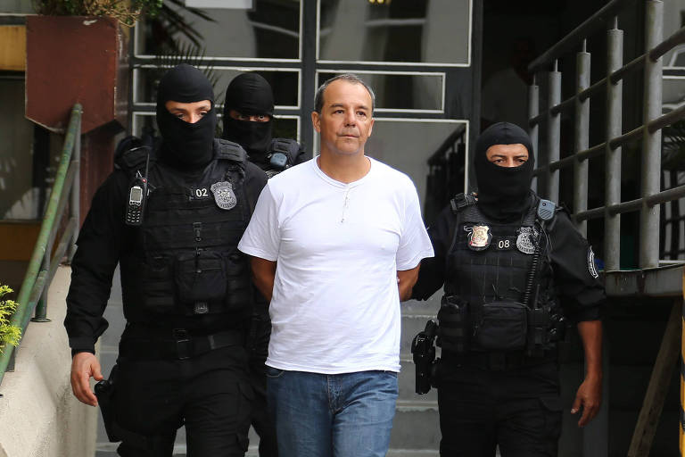 Sérgio Cabral foi preso em 17 de novembro de 2016 sob acusação de cobrar 5% de propina sobre contratos de sua gestão; na foto, ele é conduzido algemado para realizar exame de corpo de delito no IML em Curitiba, após transferência