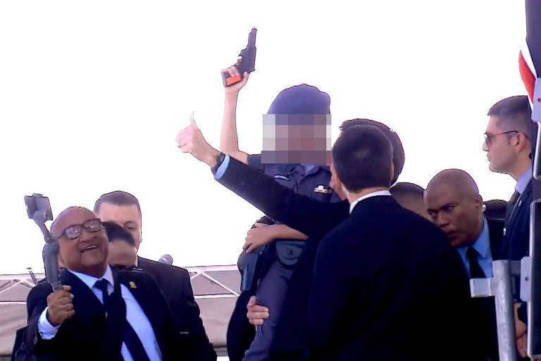 Bolsonaro segura criança no colo que aponta arma de brinquedo para o alto durante evento da PM em São Paulo