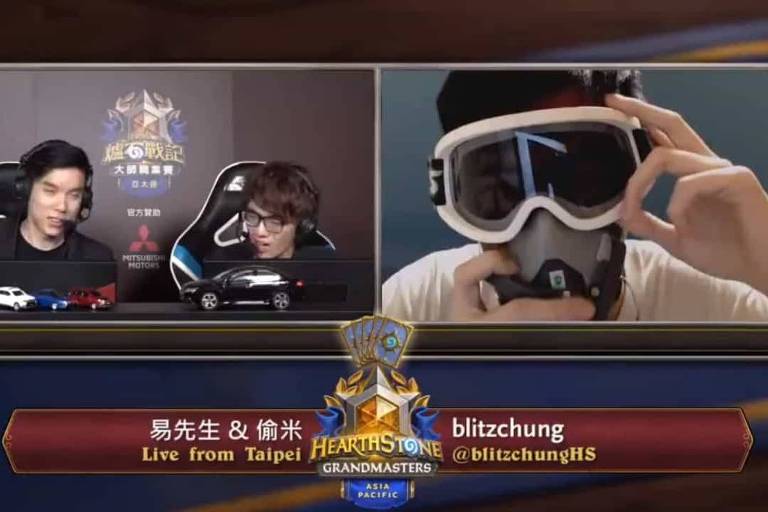 O jogador Chung Ng Wai, com óculos e máscara em referência às manifestações em Hong Kong, durante entrevista pós-partida do game Hearthstone