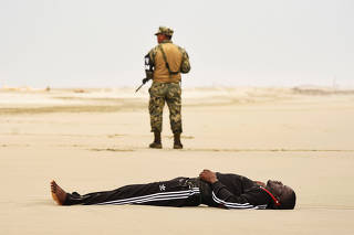 The body of a migrant man from Cameroon lies on a beach after being washed ashore following a shipwreck in Puerto Arista
