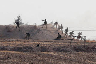 Turkey-backed Syrian rebel fighters are seen in action in the village of Yabisa, near the Turkish-Syrian border