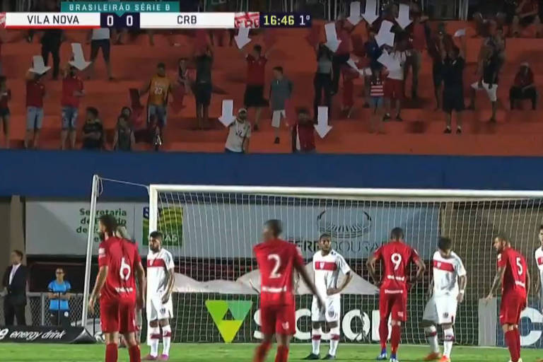 Torcedores do Vila Nova, de Goiás, apontam para a direção do gol, com setas, para "ajudar" os atacantes na partida com o CRB pela Série B do Campeonato Brasileiro