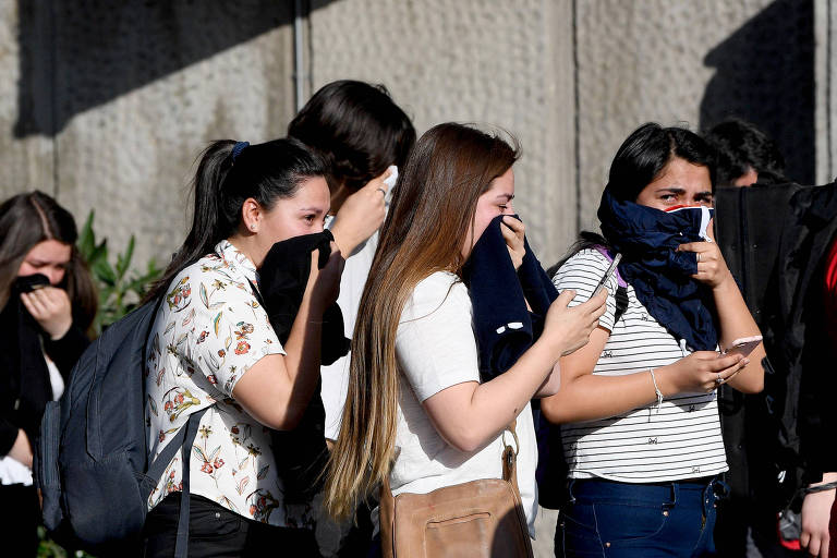 Jovens se protegem de gás lacrimogêneo