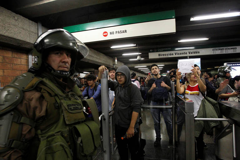 Policiais e manifestantes em protesto em estação de Santiago