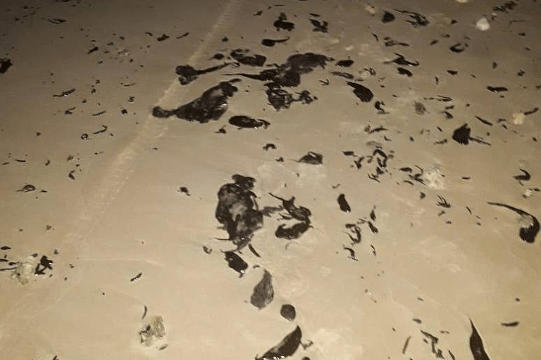 Manchas de óleo em areia da praia