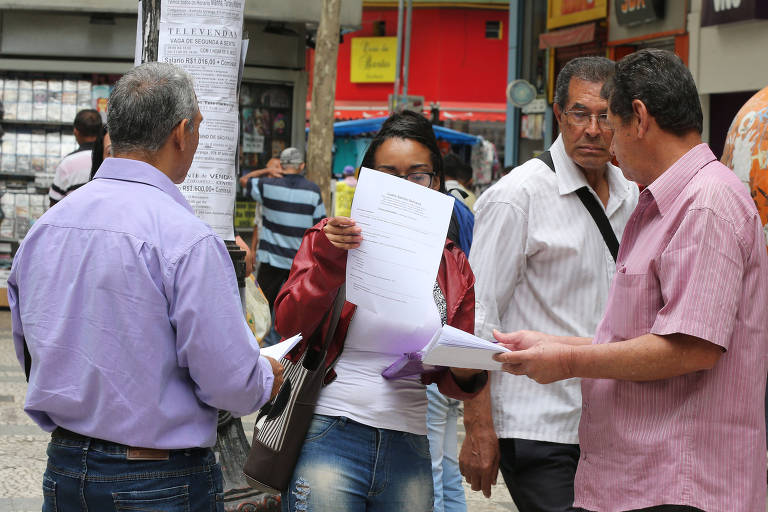 Recrutadores de agências de emprego recolhem currículos de candidatos