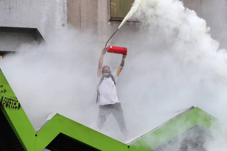 Manifestante com extintor de incêndio durante manifestação em Santiago, no Chile