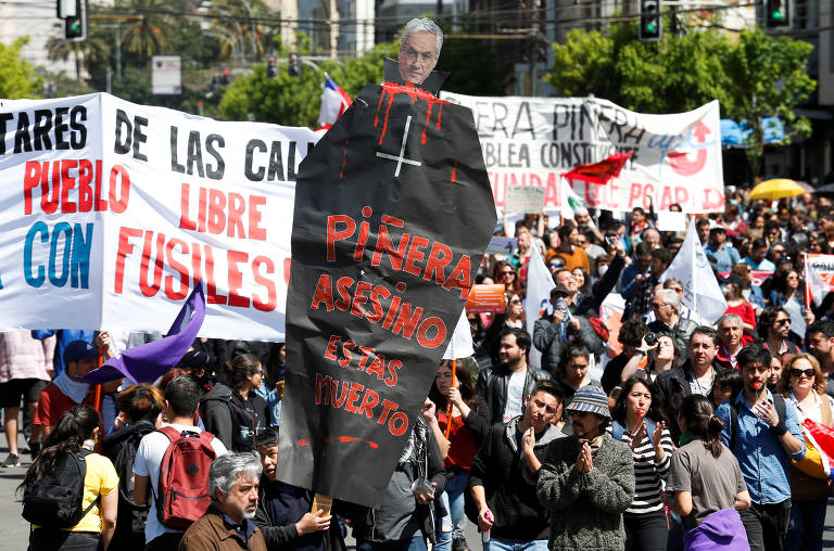 "Piñera assassino, você está morto" diz o cartaz que manifestante segura em protesto em Valparaíso