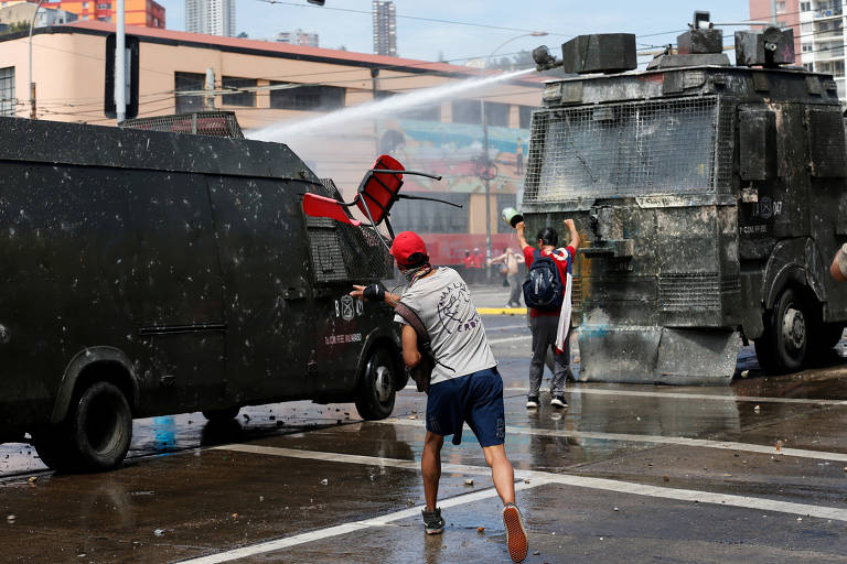 Manifestante joga objeto em veículo militar durante protesto em Valparaíso