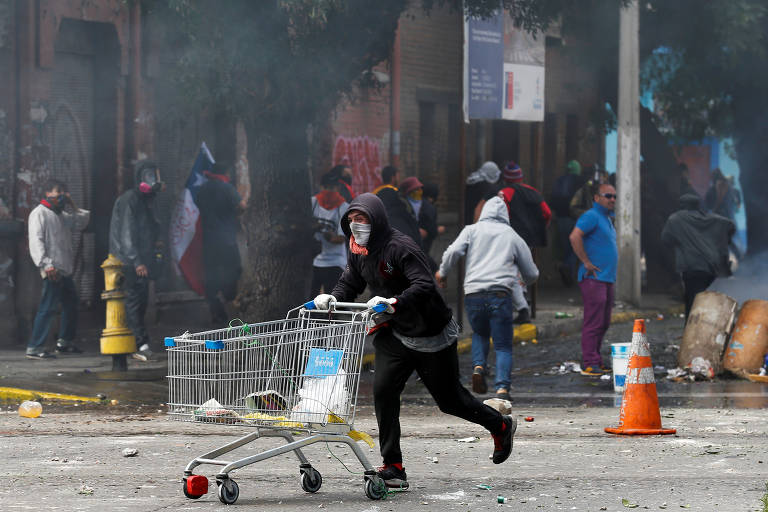 Manifestante empurra carrinho de supermercado durante protesto em Valparaíso