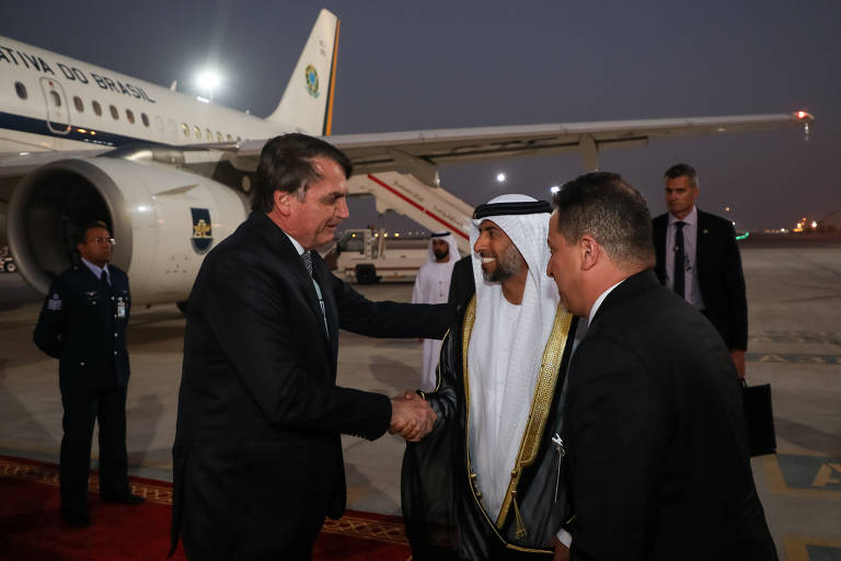 Em sua chegada a Abu Dhabi, o residente Jair Bolsonaro recebe os cumprimentos do xeque Suhail Al Mazrouei, ministro de Energia e Indústria dos Emirados Árabes