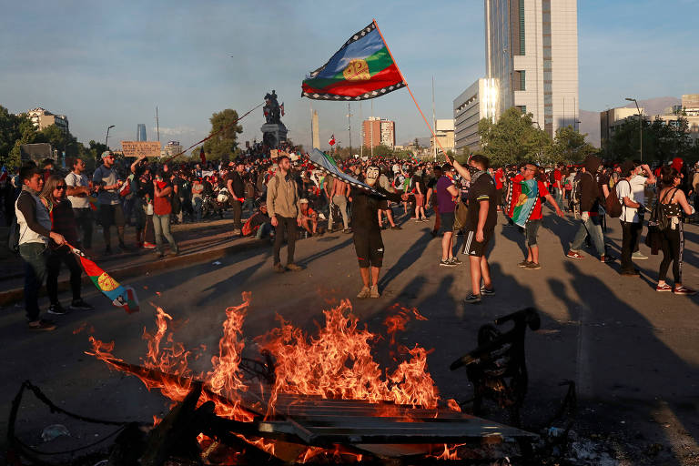 Manifestantes com bandeira mapuche durante protesto em Santiago, no Chile