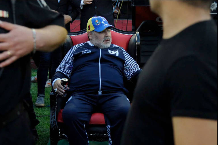 Maradona, técnico do Gimnasia, senta em um trono durante partida contra o Newll's