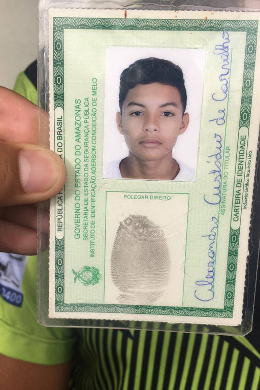 Christiane Custódio de Oliveira segura o RG de Alexsandro, 16, um dos 17 mortos pela PM