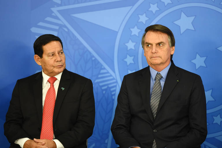 Mourão parece olhar em direção ao presidente Bolsonaro, que olha na diagonal