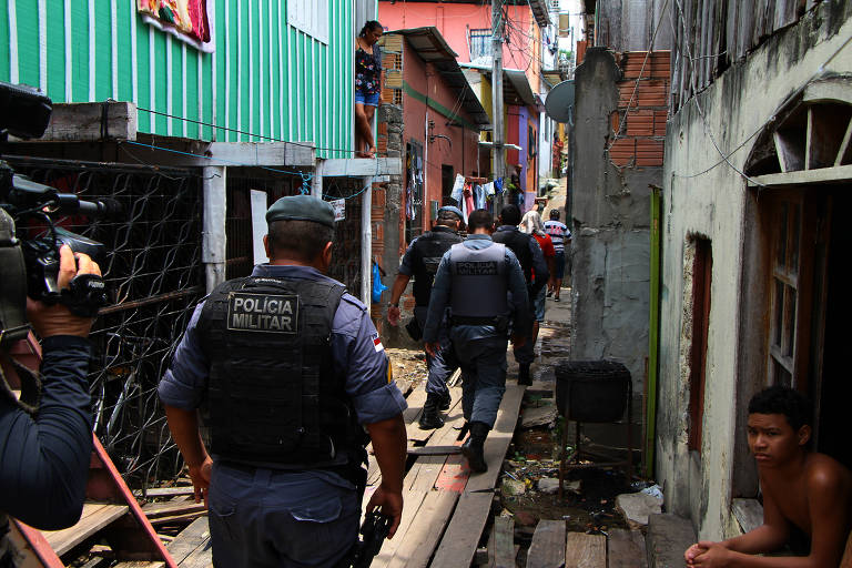 Policiais conduzem homens durante operação
