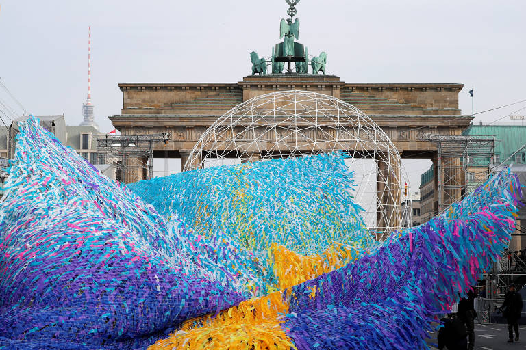 Instalação artística "Visions in Motion" é exposta em frente ao portão de   Brandenburgo, na Alemanha; obra é feita de 30 mil fitas com desejos e mensagens 