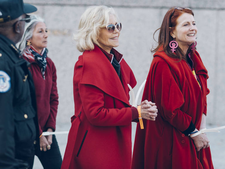 Jodie Evans (dir., com brinco rosa), mulher de Singham, é presa ao lado da atriz Jane Fonda (centro) em protesto contra mudança climática em 2019, em Washington
