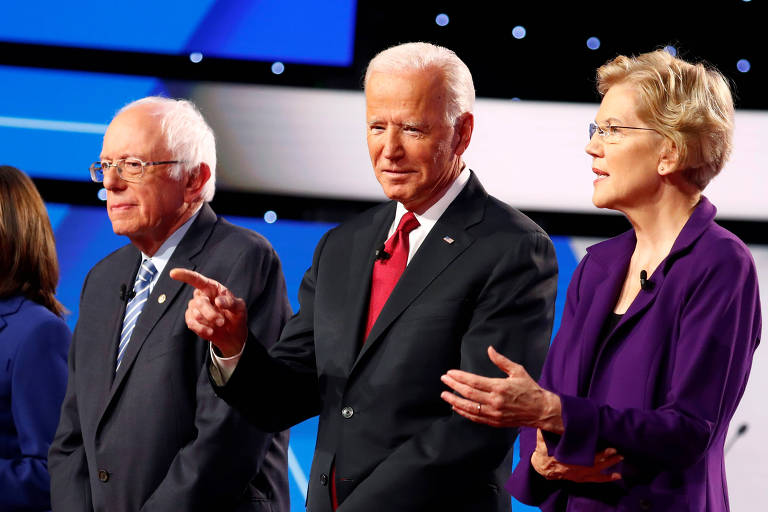 Os pré-candidatos Bernie Sanders (à esq.) e Joe Biden, ao lado da ex-pré-candidata Elizabeth Warren