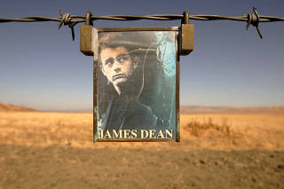 FILE PHOTO: A portrait of U.S. actor James Dean hangs from a fence near the intersection of Highways 46 and 41 n..