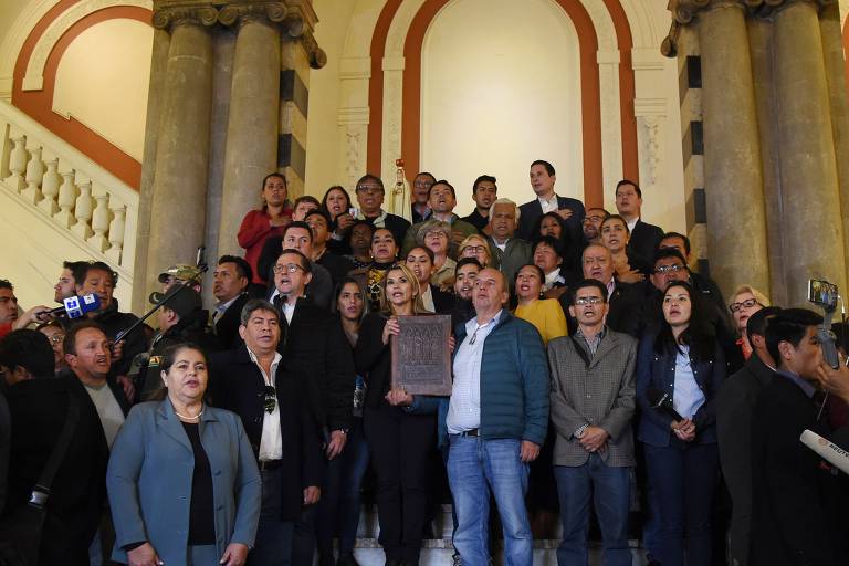 A senadora Jeanine Añez segura os Evangelhos canônicos após se declarar presidente da Bolívia, em La Paz