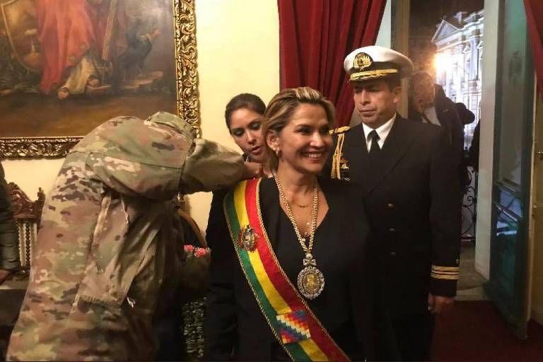 Militar ajeita faixa presidencial na presidente autodeclarada da Bolívia, Janine Aiñez