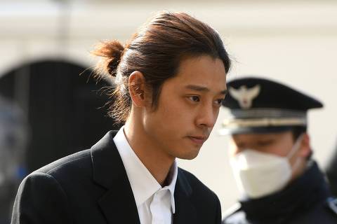 K-pop star Jung Joon-young (C) arrives for questioning at the Seoul Metropolitan Police Agency in Seoul on March 14, 2019. - A burgeoning K-pop sex scandal claimed a second scalp as a singer who rose to fame after coming second in one of South Korea's top talent shows admitted secretly filming himself having sex and sharing the footage. Jung Joon-young, 30, announced his immediate retirement from showbusiness amid allegations he shot and shared sexual imagery without his partners' consent. (Photo by JUNG Yeon-Je / AFP)