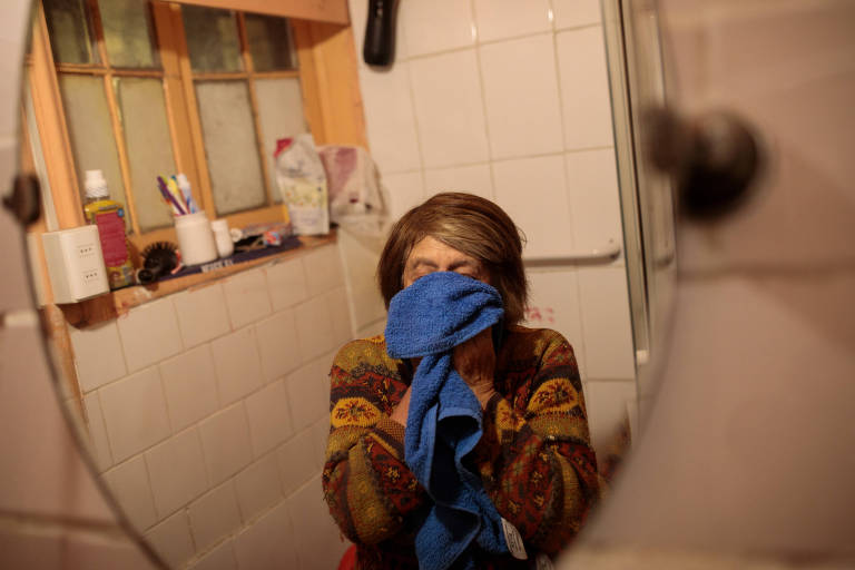 A zeladora Maria Luz Navarrete Alarcón, 70, prepara-se para ir ao trabalho