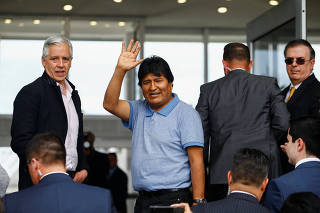 Bolivia's ousted President Evo Morales gestures during his arrival to take asylum in Mexico