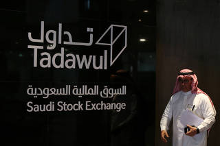 A Saudi man heads to the stock market with the start of Aramco's IPO, in Riyadh
