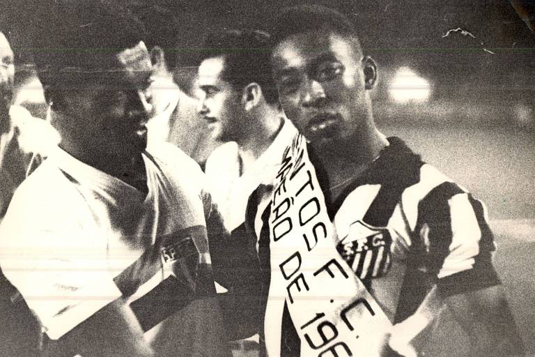 Pelé, do Santos, recebe a faixa de campeão paulista de 1961 do meia-armador Benê, após a vitória por 4 a 1 sobre o São Paulo, na Vila Belmiro, na última rodada