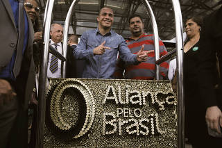 Apoiadores de sigla criada por Bolsonaro posam com peça com o logotipo do partido