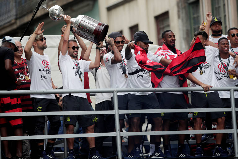 Jogadores do Flamengo exibem o troféu da Libertadores em desfile de carro aberto pelas ruas do Rio