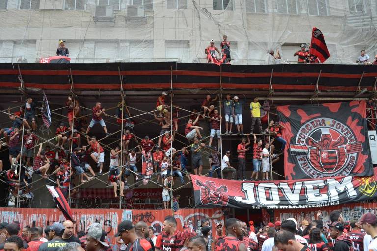 Torcedores se equilibram em andaimes à espera do trio elétrico com os atletas do Flamengo. A festa no centro do Rio comemora o bicampeonato da Libertadores